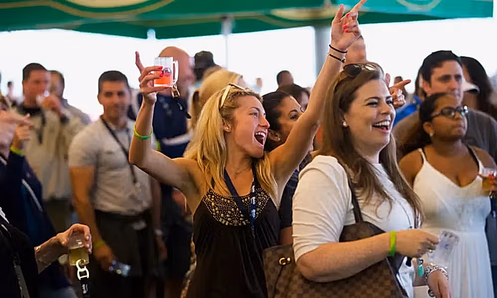 Woman with beer tasting in her hand singing at NJ Beer and Food Festival.