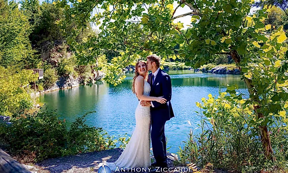 Groom kisses bride in front of Quarry Cliffs. 