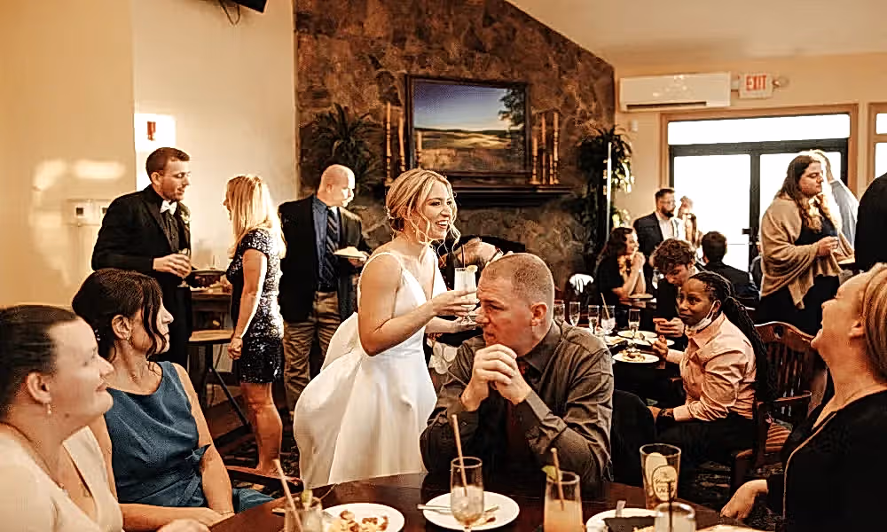 Bride holding drink during cocktail hour.