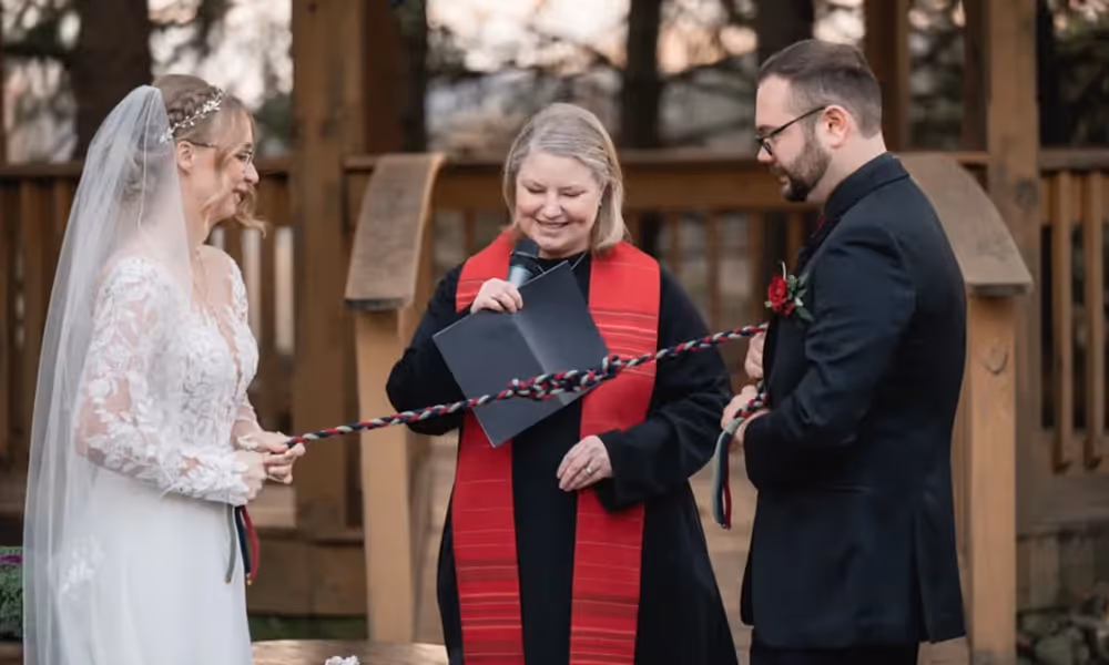 Bride, groom and officiant stand at altar at Black Bear wedding ceremony. 