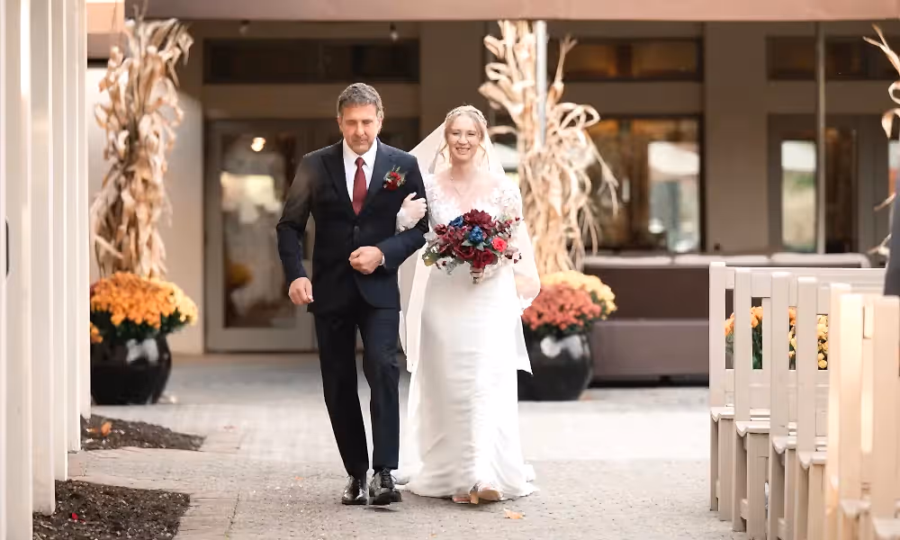Bride and man walk down aisle together at Blac Bear wedding ceremony.
