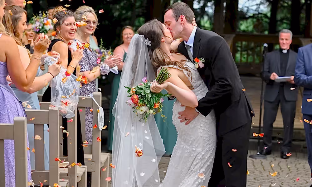 Groom dips bride and gives her a kiss as they walk back down the aisle at Black Bear wedding ceremony. 