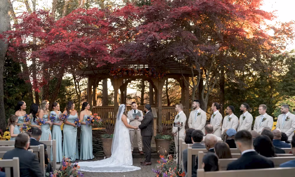Bride, groom and all wedding party stand at altar at Black Bear wedding ceremony. 