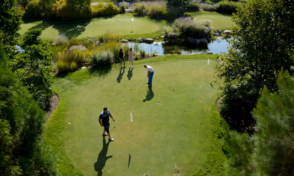 Friends playing on the putting course at Grand Cascades Lodge