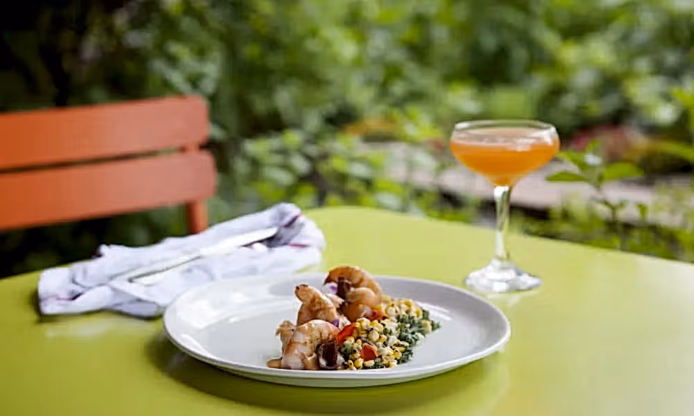Food paired with orange colored cocktail in Chef's Garden.