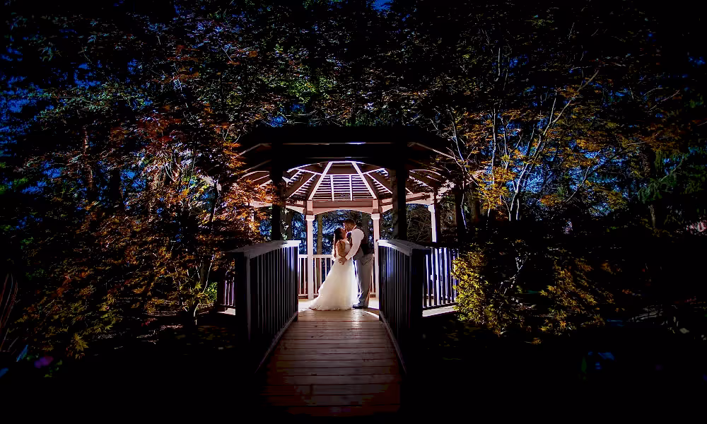 Bride and groom kissing in lit up Black Bear gazebo