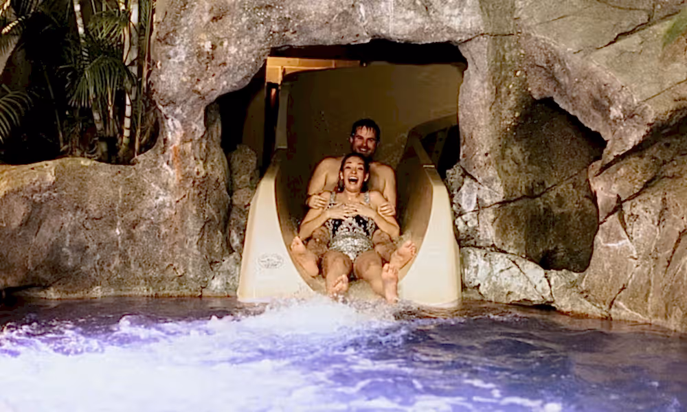 Bride and groom going down waterslide at Biosphere