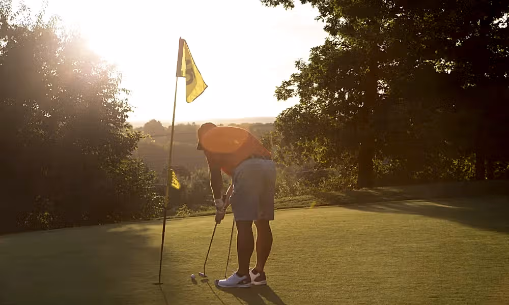 Man making his putt at a hole on Black Bear Golf Course
