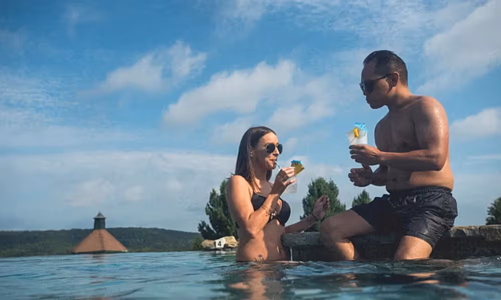 Couple enjoying cocktails at a resort outdoor pool