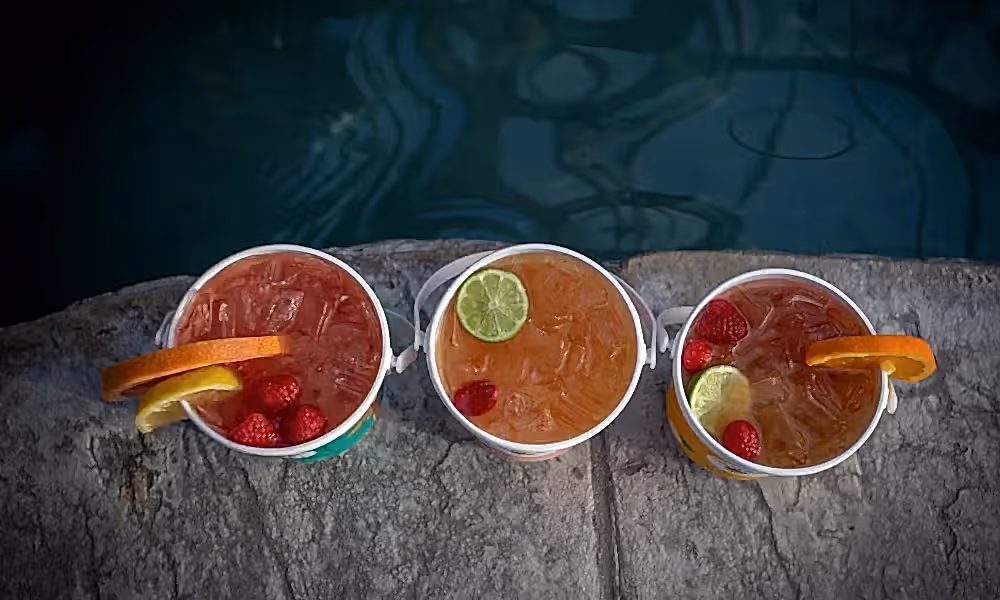 Aerial view of three rum buckets with fresh fruit.