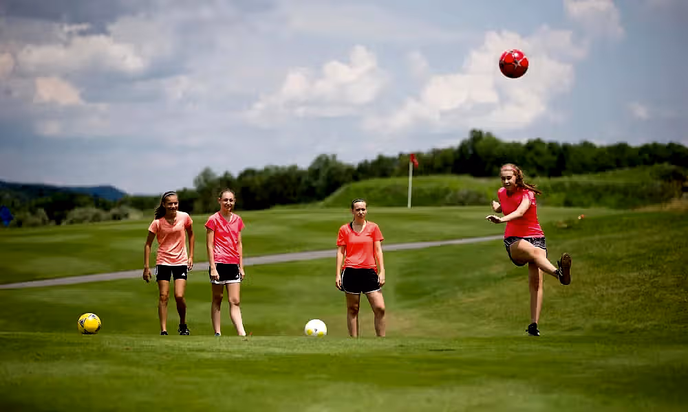 Young girls playing foot golf on a golf course at Crystal Springs Resort