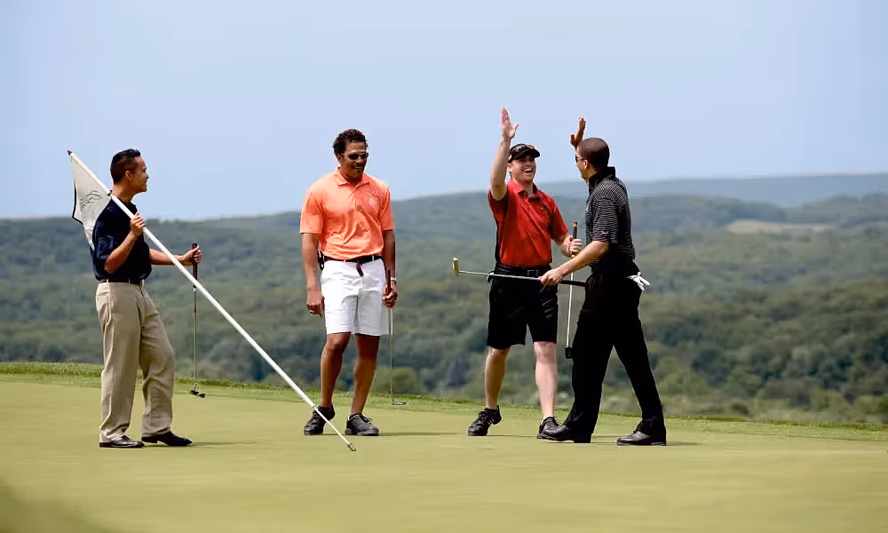 Four golfers on the putting green
