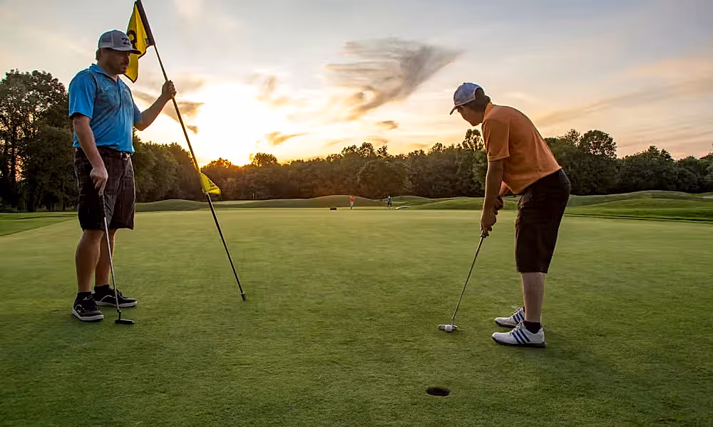 Two men on the putting green of a hole at Black Bear Golf course