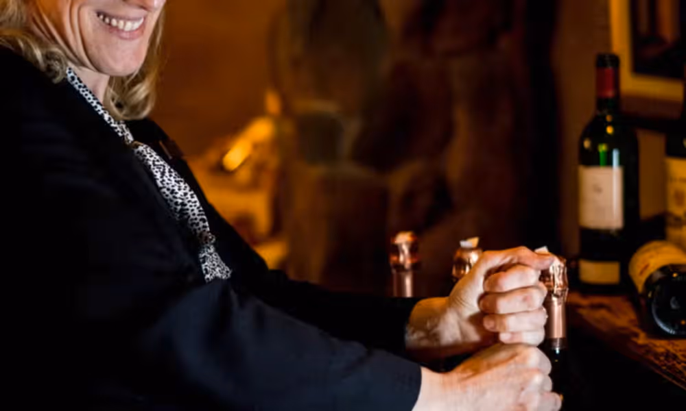 Susanne Wagner opening a bottle of wine.