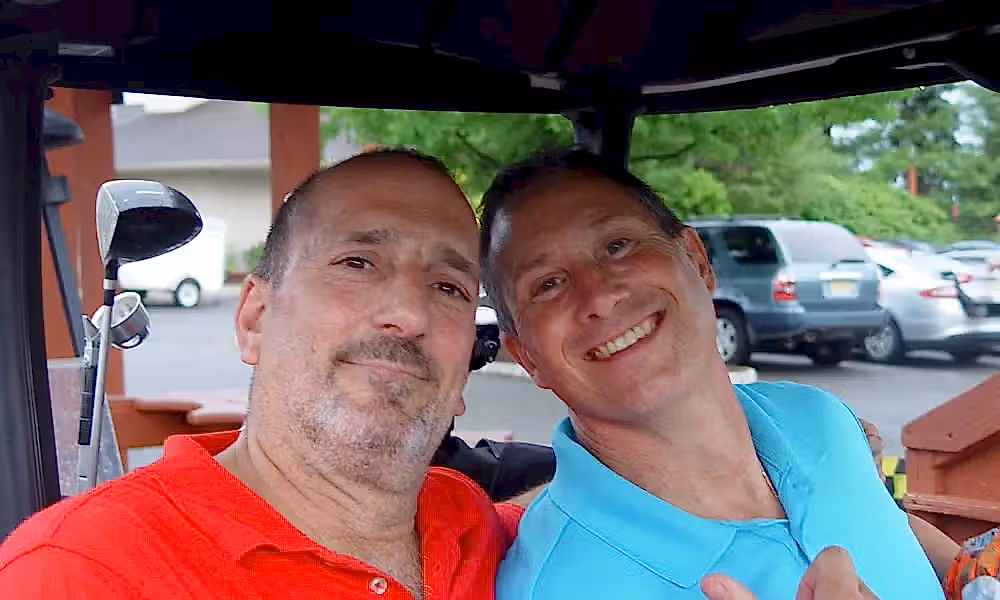 Men smiling in golf cart at Black Bear Bourbon &amp; BBQ