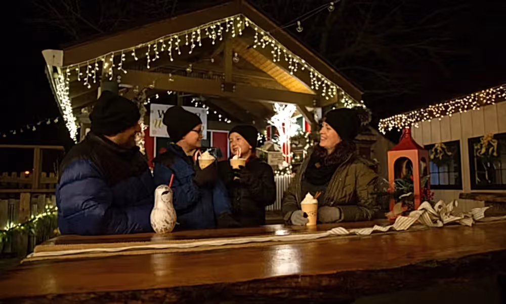 Family of 4 drinking festive drinks in Frosty's Cantina during vacation.