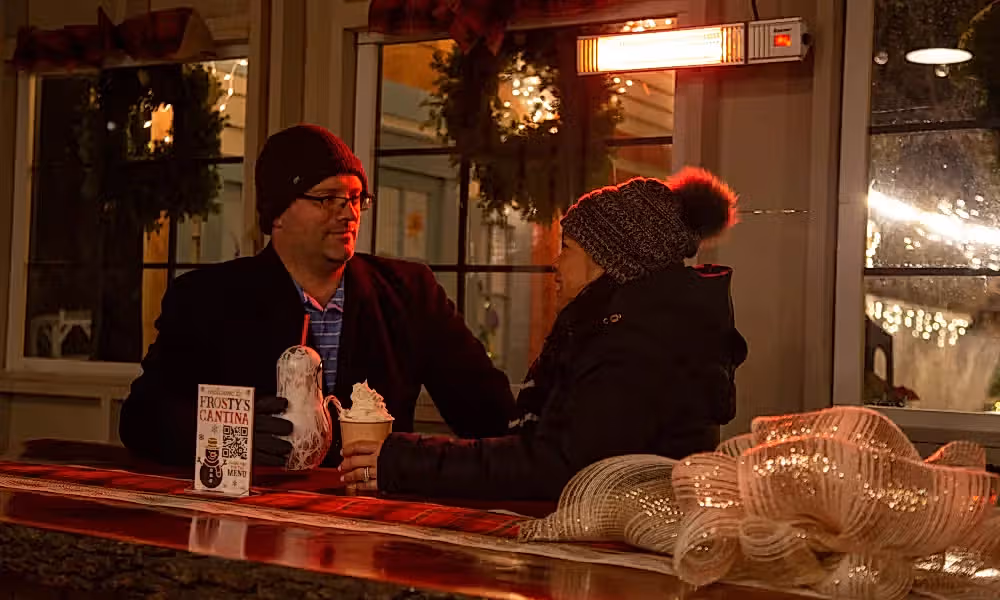 Couple sitting in Frosty's Cantina drinking festive beverages.