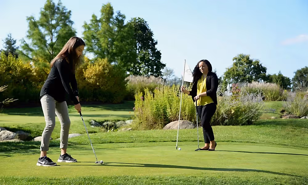 Girlfriends playing on the natural grass putting course at a resort close to NYC
