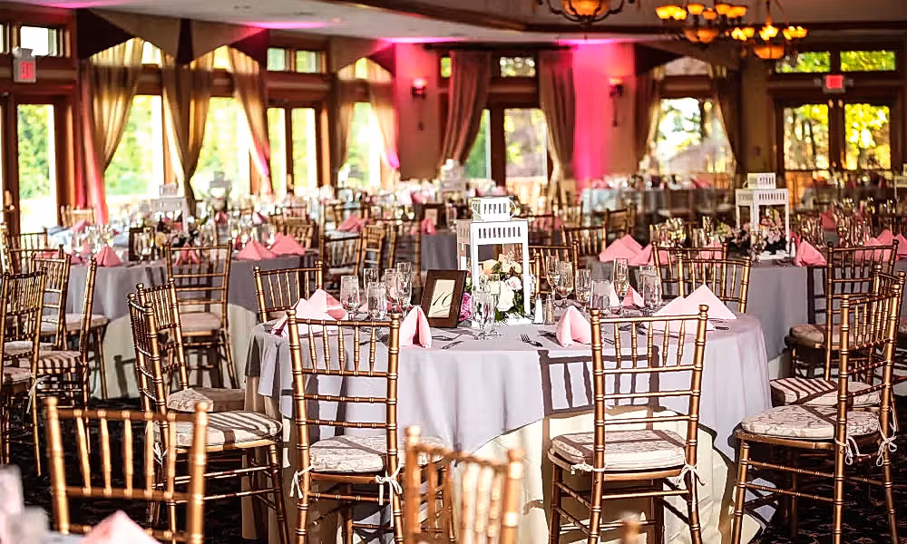 Wedding reception tables with pink uplighting at Black Bear Golf Club.