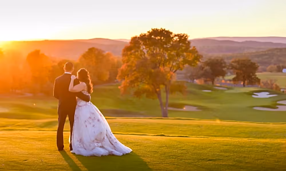 Wedding couple overlooking golf course at sunset