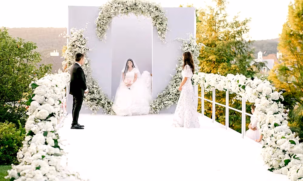 Bride walking down aisle during wedding ceremony in amphitheater. 