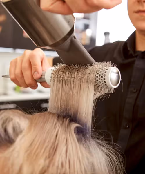 Woman getting her hair blown out at salon.