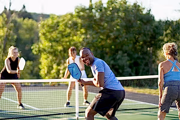 Four people playing pickleball