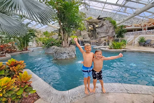 Two boys with their arms around eachother standing outside Biosphere pool.