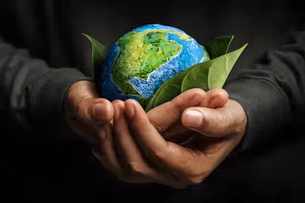 Two hands holding small world globe.