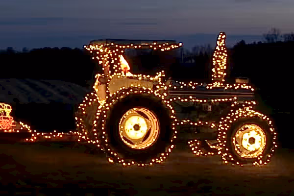 Tractor that is covered in Christmas lights.