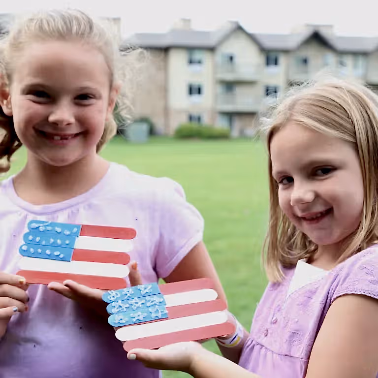 Two girls holding a handmade american flag craft