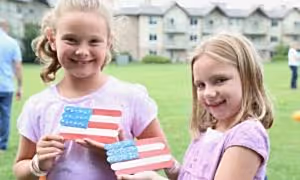 Two girls holding a handmade american flag craft