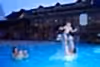 Father throwing son up in air in pool.