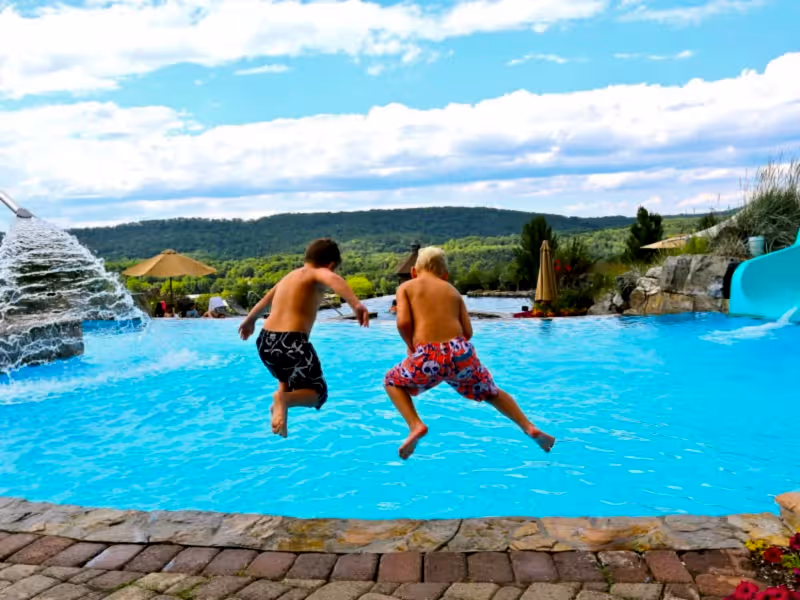 Two children jumping into vista 180 pool.