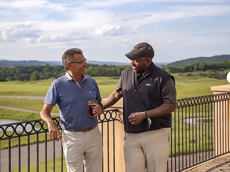 Guys enjoying drinks on the outdoor patio of a golf club at Crystal Springs Resort